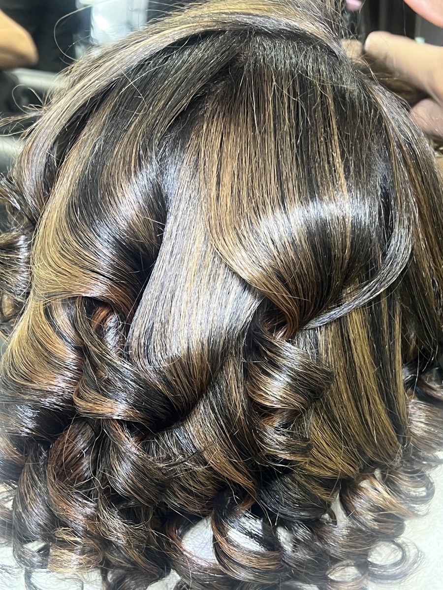 Brown hair with caramel highlights styled in soft curls