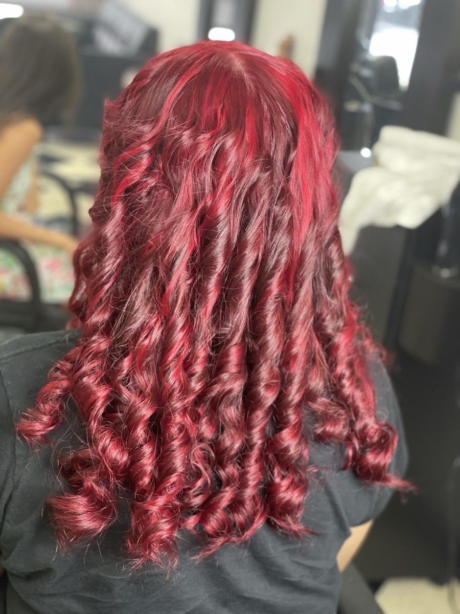 Vibrant red spiral curls colored at Yokasta Dominican Hair Salon