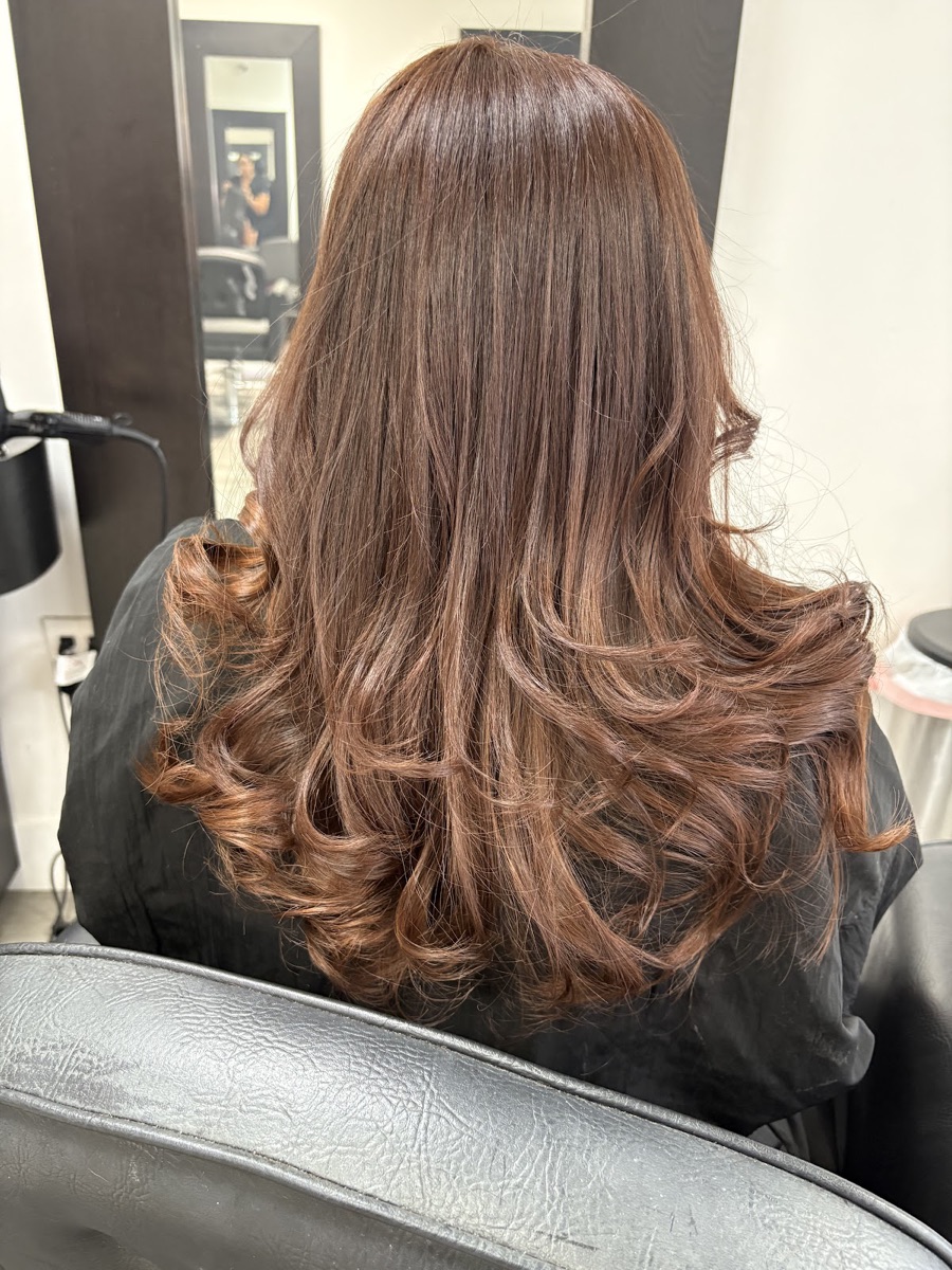 Long auburn layered curls with rich color and shine